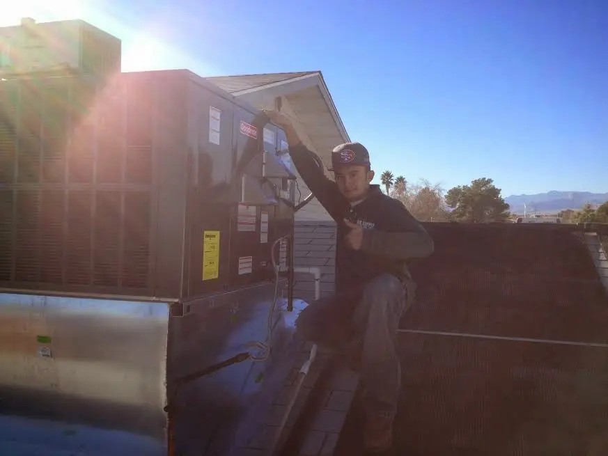 HVAC technician performing Boiler Repair on a rooftop unit in Austin